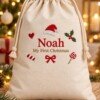 Cream Christmas gift sack embroidered with Noah and My First Christmas in a festive setting