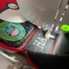 Embroidery machine stitching the name Harlan onto a black Pokémon lunch bag